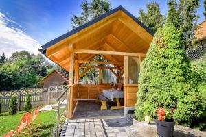 a wooden gazebo with a bench in a garden at Domek Pod Brzyzkiem in Białka Tatrzanska
