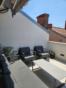 a patio with chairs and tables on a roof at Sebenico Luxury Rooms 2 in Šibenik