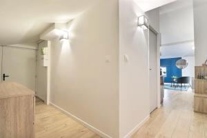 a kitchen and living room with white walls and wood floors at Le St Clair 403 - Luxury & fully equipped apartment - Caluire-et-Cuire in Caluire-et-Cuire +2 photos
