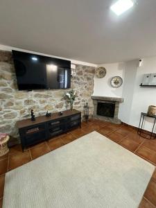 ein Wohnzimmer mit einem TV und einem Kamin in der Unterkunft casa dos Ferreira no Douro in Ucanha