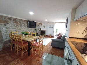 a kitchen and living room with a wooden table and chairs at casa dos Ferreira no Douro in Ucanha
