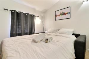a white bed with two towels on top of it at Le St Clair 401 - Luxury equipped apartment - Caluire-et-Cuire in Caluire-et-Cuire +7 photos
