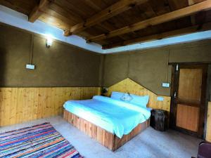 a bedroom with a large bed with a wooden headboard at Tirthan Ecostay in Gushaini