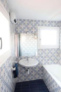 Un baño con lavabo y azulejos azules y blancos. en Charming house in Sant Pol facing the sea, en Sant Pol de Mar