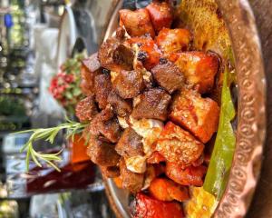a plate of food with meat and vegetables on it at Transilvania Garden House in Miercurea-Ciuc