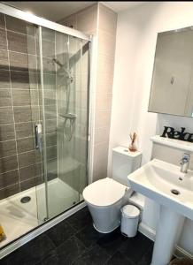 Un baño con ducha, inodoro y lavabo. en Walker House, en Gloucestershire