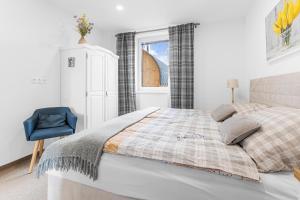 a bedroom with a bed and a blue chair at vila Lešťo in Veľká Lomnica