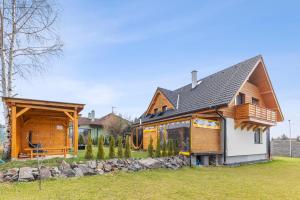 a wooden house with a gambrel roof at vila Lešťo in Veľká Lomnica