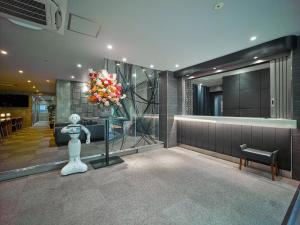 a lobby with a vase of flowers in a room at Hotel Sunplaza 2 Annex in Osaka