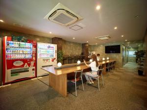 a woman sitting at a long table in a restaurant at Hotel Sunplaza 2 Annex in Osaka