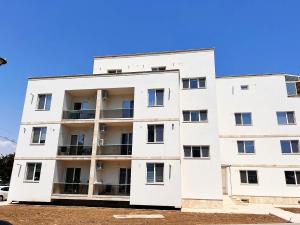 an image of a white apartment building at Rion Apartment in Saturn