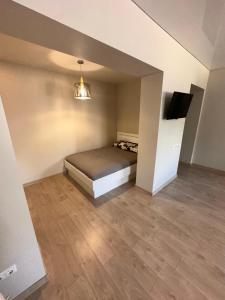 a room with a bed and a tv in it at Studio flat Centrinis Butukas in Kėdainiai
