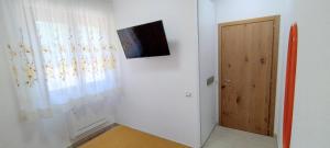 a room with a television on the wall and a door at Camere Vetralla in Fabriano