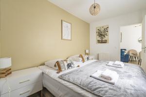 une chambre avec un grand lit avec des serviettes dessus dans l'établissement Pentagone 1 SPA PRIVE, à Reims