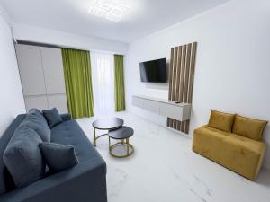 a living room with a blue couch and a table at Wave 6 Apartments in Năvodari