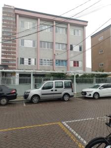 trois voitures garées sur un parking devant un immeuble dans l'établissement Coração da Ocian, à Praia Grande