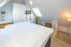 a bedroom with a large white bed in a room at Möwennest App 18 in Wenningstedt