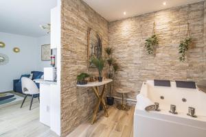Cette chambre est dotée d'un mur en briques et d'une table avec des plantes. dans l'établissement Pentagone 1 SPA PRIVE, à Reims 9 autres photos