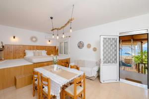 a bedroom with a bed and a dining room with a table at Korali Sea House in Archangelos