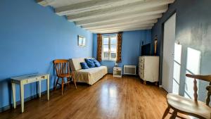 sala de estar con paredes azules y sofá en Sainte-Suzanne gîte de LA FERME calme et tranquille, en Les Baux-de-Breteuil