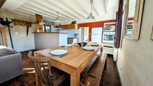 una cocina con una mesa de madera con platos. en Sainte-Suzanne gîte de LA FERME calme et tranquille, en Les Baux-de-Breteuil