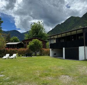 un edificio con un cortile con due panche bianche di Bungalow Green Holiday a Ledro