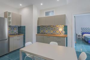 een keuken met een tafel en stoelen in een kamer bij Amami Home in Salerno +16 foto's