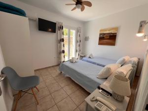 a bedroom with two beds and a table and a chair at Danaides Studios in Batsi