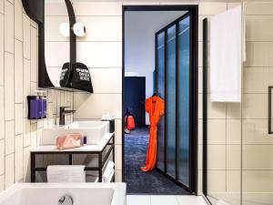a bathroom with an orange umbrella in the doorway at Tribe Paris La Defense Esplanade in Courbevoie