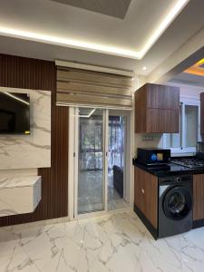 una cucina con piano cottura, lavatrice e asciugatrice di appartement riad sofia a Martil