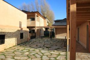 een stenen loopbrug voor een gebouw bij Alojamiento Ubaldo Nieto in Carracedo del Monasterio