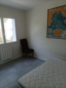 ein Schlafzimmer mit einem Bett, einem Stuhl und einer Karte in der Unterkunft plain pied proche de la plage in Saint-Georges-de-Didonne