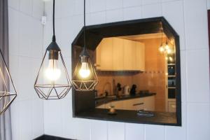 a mirror on the wall of a kitchen with lights at House 37North in Mosteiros +47 photos