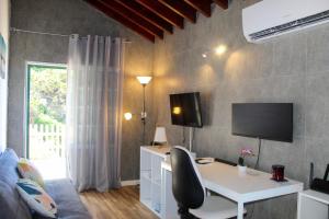a room with a desk and a tv on a wall at House 37North in Mosteiros