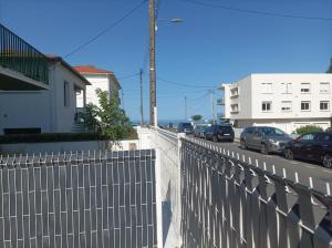 ein Zaun am Straßenrand mit geparkten Autos in der Unterkunft plain pied proche de la plage in Saint-Georges-de-Didonne