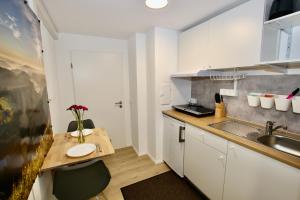 a small kitchen with a table and a sink at Gemütliches Schwarzwald-Apartment im ruhigen Untergeschoss eines Hauses in Denzlingen
