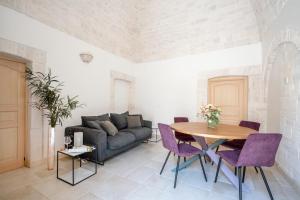 アルベロベッロにあるTrulli Contento - Rooms & Apartmentsのソファとテーブルのあるリビングルーム