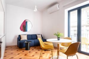 a living room with a blue couch and a table at MIXT by Zoia Living in Athens