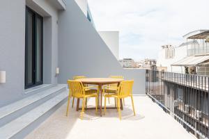 a table and chairs on the balcony of a building at MIXT by Zoia Living in Athens