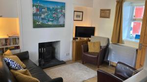 a living room with a couch and a fireplace at 105 Seatown in Cullen