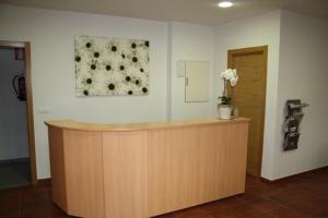 een lobby met een balie met een bloemschilderij aan de muur bij Alojamiento Ubaldo Nieto in Carracedo del Monasterio