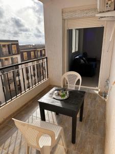 スキクダにあるAppartement F3 Bouzaaroura Skikdaのリビングルーム(テーブル、椅子付)