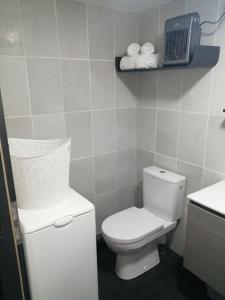 a white bathroom with a toilet and a sink at Appartement tout proche de Bourg-en-Bresse in Péronnas