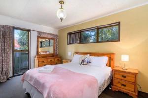 a bedroom with a large bed and two windows at Hopoe City Villa in Rotorua +3 photos