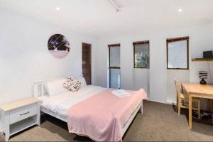 a bedroom with a bed and a desk and a table at Hopoe City Villa in Rotorua