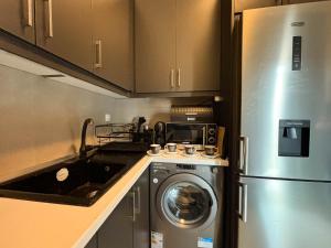 a kitchen with a refrigerator and a washing machine at Kassiopi Bella Vista in Kassiopi