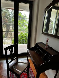 a piano and a chair in a room with a window at Relais La Villa in Lucera