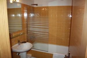 een badkamer met een wastafel en een ligbad bij Alojamiento Ubaldo Nieto in Carracedo del Monasterio +14 foto's