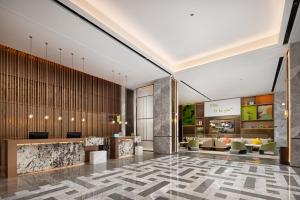 a lobby of a hotel with couches and tables at Home2 Suite by Hilton Wuhan Economic Development Zone in Wuhan