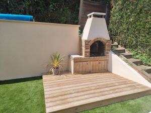 a wooden deck with a fireplace in a backyard at Spassionnement pool in Jouy-le-Moutier